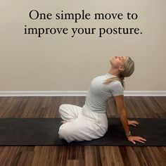 a woman sitting on a yoga mat with her eyes closed and hands in the air