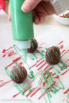 someone is decorating chocolate covered strawberries with green and red sprinkles