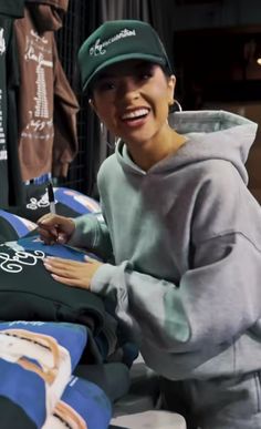 a woman smiles as she signs t - shirts for sale