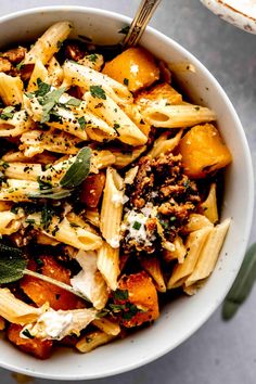 a white bowl filled with pasta and vegetables