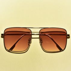 These 1970s vintage style sunglasses feature an oversized square lens, are outlined with a chic gold rim, provide UV 400 protection and comes in three translucent colors. Each sold separately. Dimensions: Length: 6 inches Lens diameter: 2.2 inches Retro Square Frame Metal Sunglasses, Retro Square Frame Aviator Sunglasses For Summer, Retro Shield Sunglasses With Square Frame And Tinted Lenses, Brown Metal Frame Shield Sunglasses For Summer, Retro Gold Aviator Sunglasses With Gradient Lenses, Gold Retro Aviator Sunglasses With Gradient Lenses, Gold Retro Sunglasses For Summer, Retro Gold Sunglasses For Summer, Retro Gold Rectangular Sunglasses