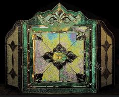 an art nouveau style stained glass window with gold and green designs on the sides, in front of a black background