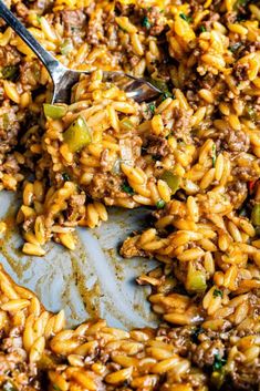 a close up of some food in a pan with a spoon on top of it