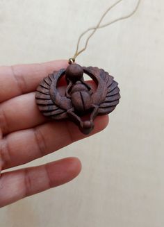 a hand holding an ornament with a bird on it