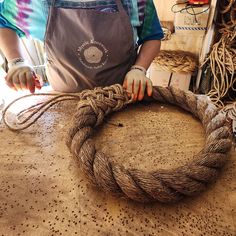 a man is making a rope wreath out of twine on a table with other items in the background