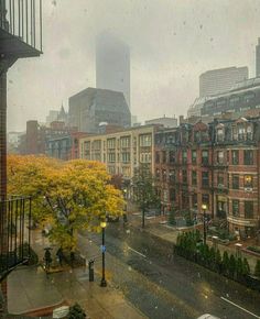 a city street filled with lots of traffic under a rain covered sky scraped window