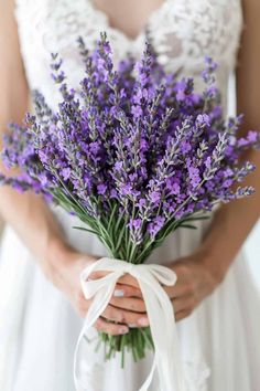 a woman holding a bouquet of lavender flowers