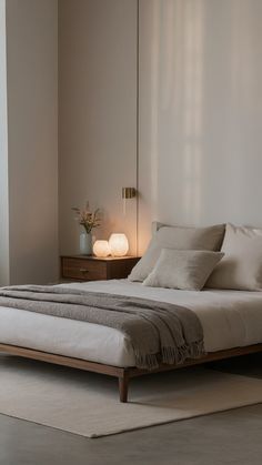 a white bed sitting next to a window in a room with two lamps on either side of the bed