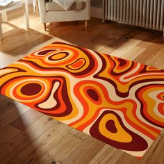 an orange, red and yellow rug on the floor in a room with a radiator