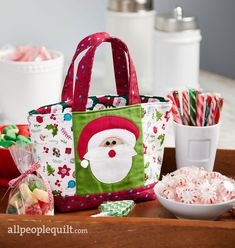 a santa clause bag sitting on top of a table next to candy and candies