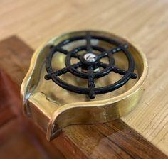 a close up of a metal object on a wooden surface