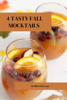 two glasses filled with fruit and ice on top of a white table next to leaves