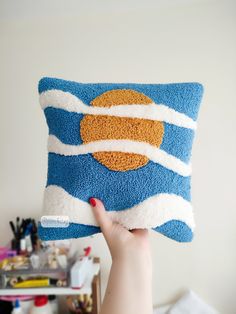 a person holding up a blue and white pillow