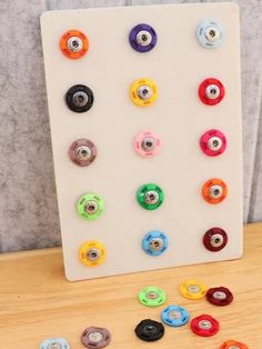 there are many different colored buttons on the board and next to it is a button holder