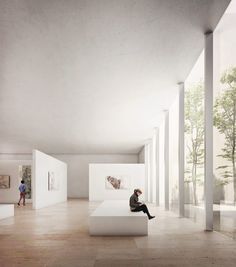 a person sitting on top of a white bench in a room filled with tall columns