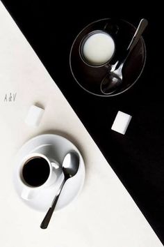 a cup of milk and spoons on a table