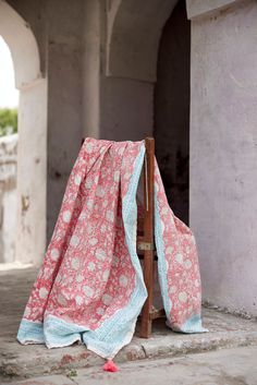 a chair with a blanket on it sitting in front of an arch and doorways