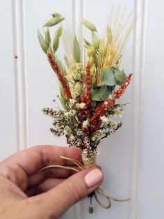 a person is holding a bunch of flowers in their hand while they are on the wall