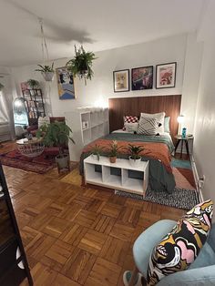 a bed room with a neatly made bed and lots of plants on the wall next to it