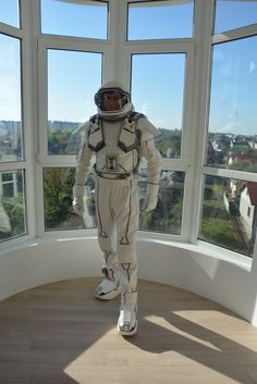 an astronaut suit on display in front of large windows