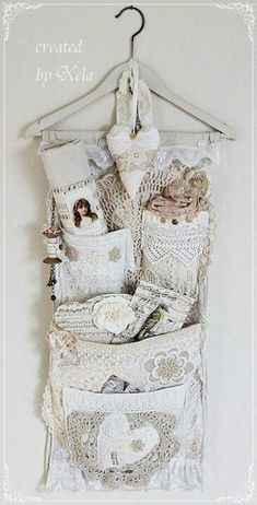 there is a white wall hanging on the wall with many different things in it, including pillows and doily