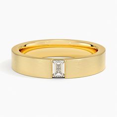 a yellow gold ring with a baguette cut diamond