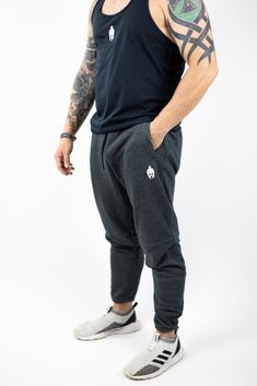 man modeling Strength of One gray sweatpants with embroidered helmet logo at top right hip and Strength of One logo vertical down left lower leg Gym Closet, Stringer Tank Top, Outfit Oversize, Sport Bra Top, Closet Staples, Short Jumpsuit, Bra Tops, Sport Outfits, Moisture Wicking