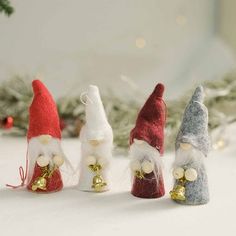 three gnomes with bells in front of a christmas tree