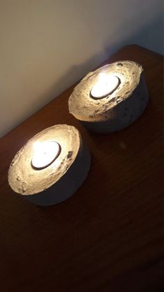 two white lights sitting on top of a wooden table