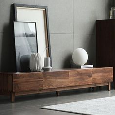 a living room with a wooden entertainment center and white vases on top of it