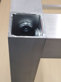 a metal object with a camera inside of it's hole in the side of a table