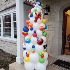 a large balloon christmas tree in front of a house