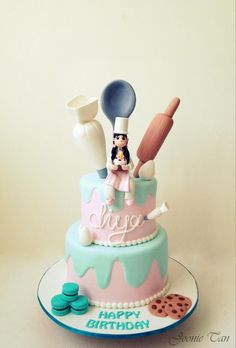 a birthday cake decorated with baking utensils and cookies