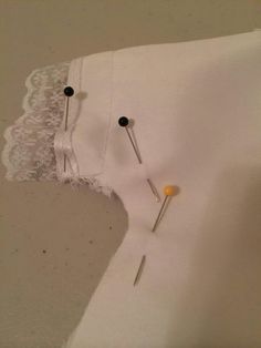 two pins are stuck in the white fabric