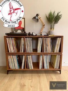 an old record player is sitting on top of a bookcase with records in it