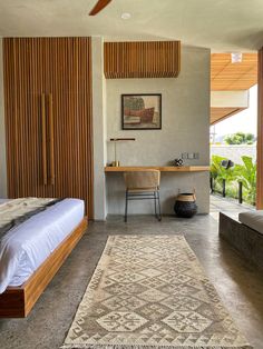 a bedroom with a bed, desk and ceiling fan