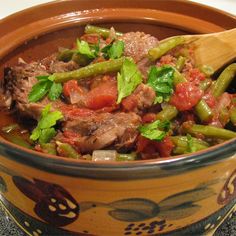 a bowl filled with meat and vegetables on top of a table