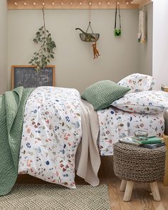 a bed room with a neatly made bed next to a wooden shelf filled with potted plants