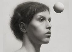 a black and white photo of a woman's face with an egg above her head