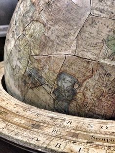 an old wooden globe sitting on top of a table