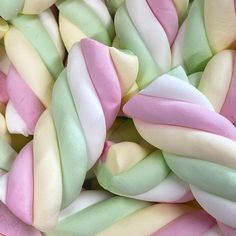 there are many different colored candies in the pile together and one is pink, green, yellow, and white