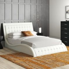 a white bed sitting on top of a wooden floor