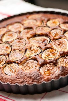 there is a chocolate pie with bananas in it on a tablecloth and red checkered napkin