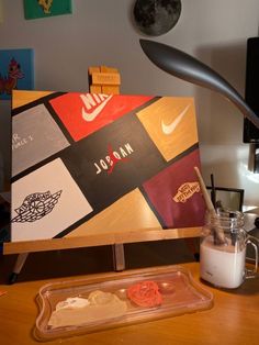 a wooden table topped with lots of food and art work on it's sides