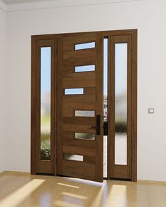 an empty room with two wooden doors on the wall and wood flooring in front of it