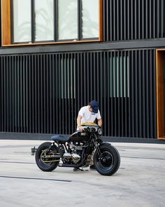 a man sitting on top of a black motorcycle