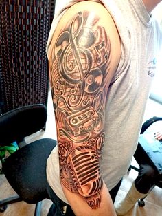 a man with a microphone tattoo on his arm