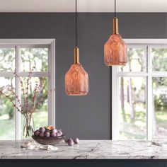 three lights hanging over a marble counter top