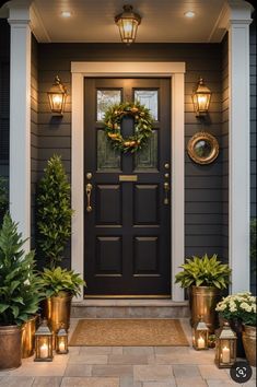 a front door with potted plants and lanterns