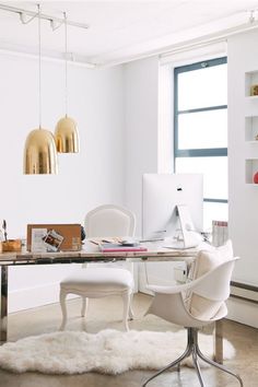 an office with white furniture and gold fixtures in the background, along with a large window